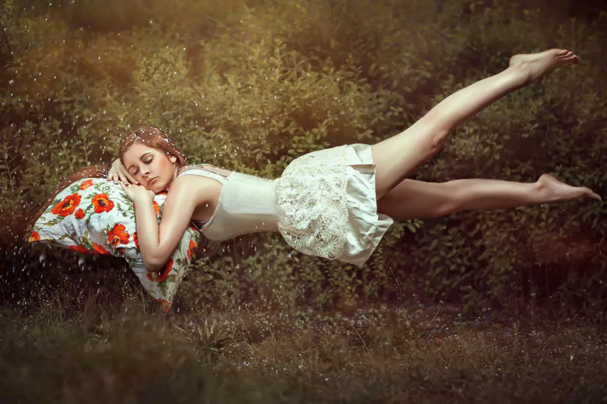 Levitation girl on a bed in a sweet dream.