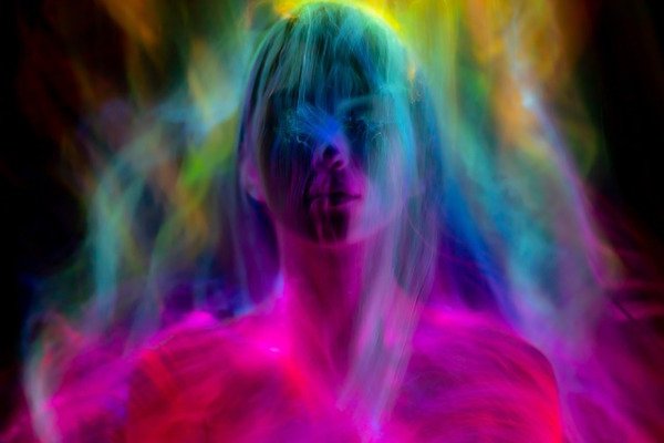 Portrait of a woman with a calm, focused gaze, illuminated by ethereal light to evoke inner power and spiritual mystery.